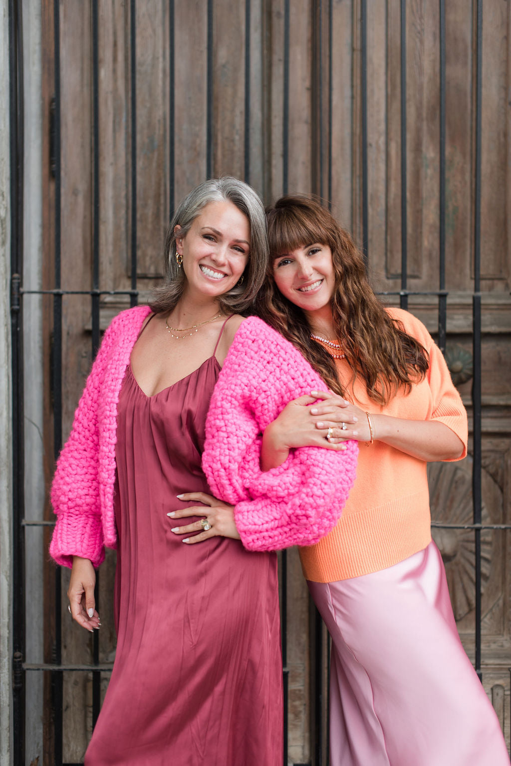 Female founders together in front of vintage wood door