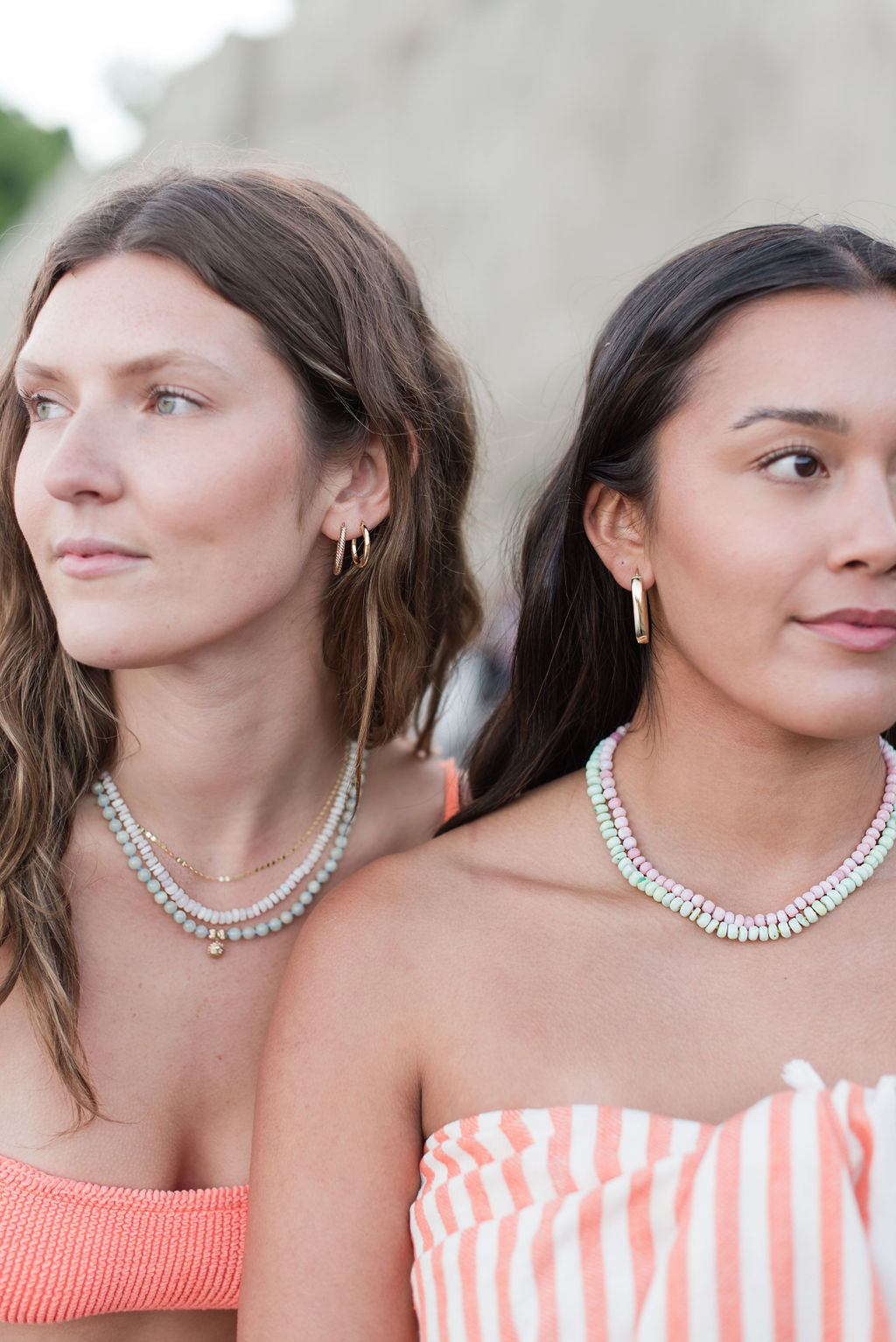 Women wearing beaded necklaces and gold hoop earrings at the beach